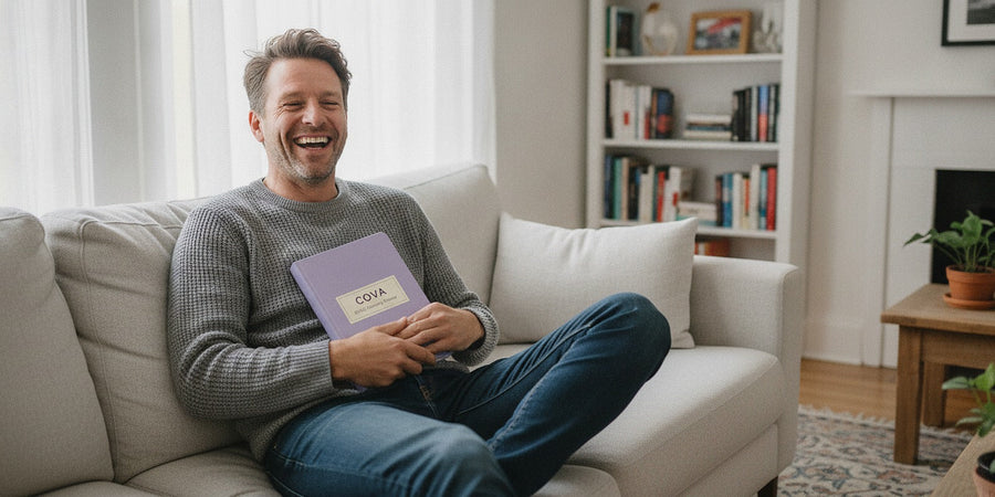 A man smiling on a sofa holding the planner