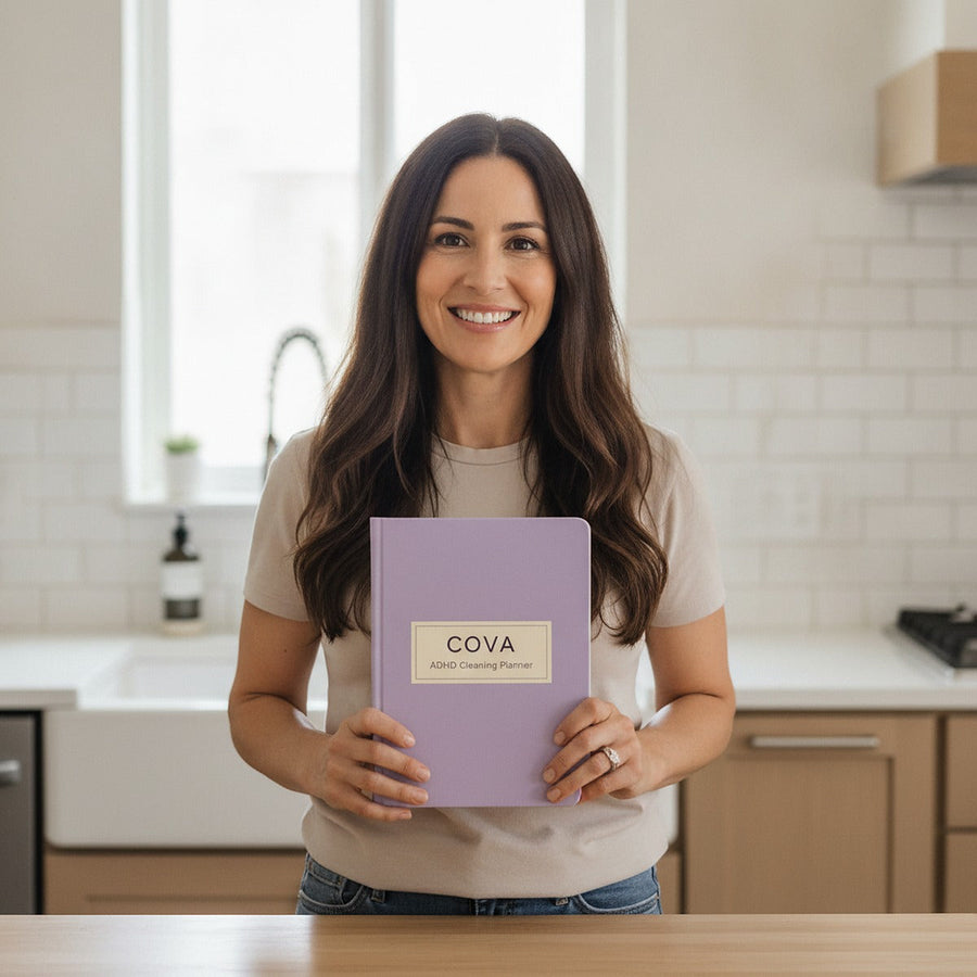 A woman in her tidy kitchen holding the planner