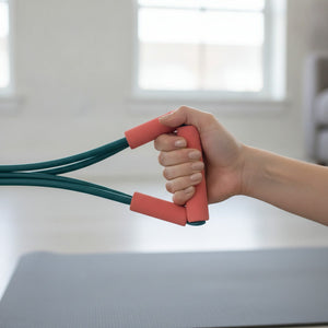 Hand gripping a coral foam handle of the COVA band